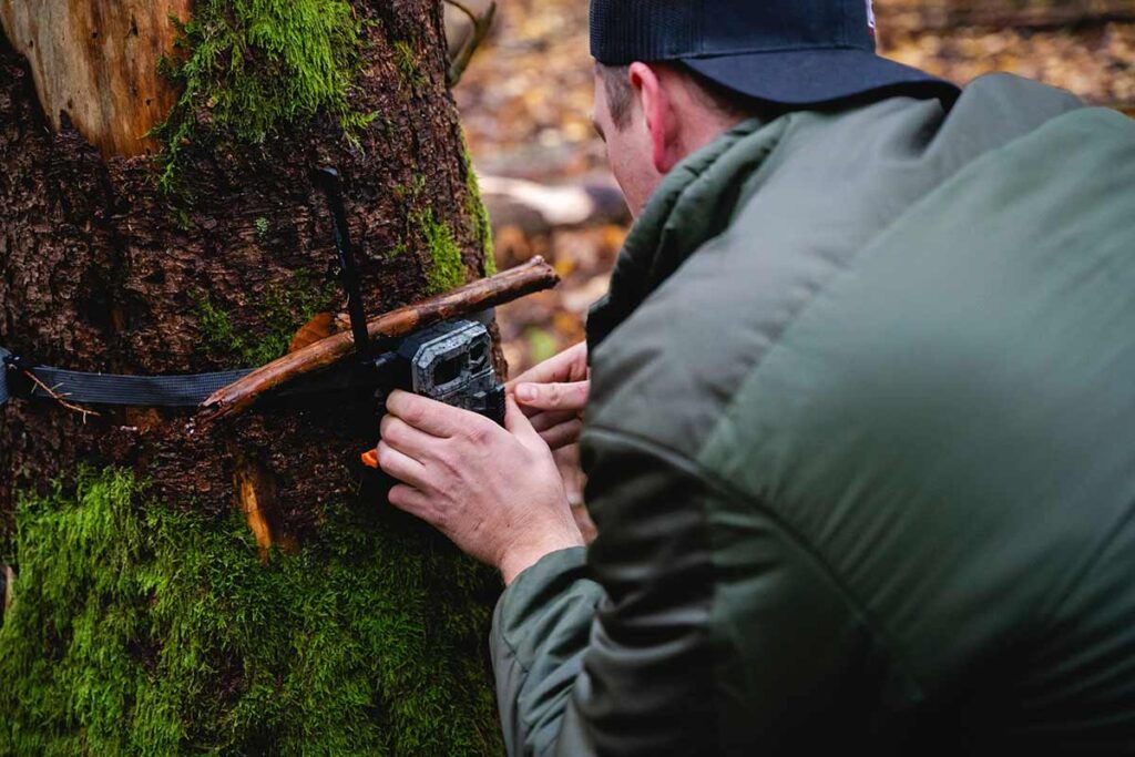 Person setting up trail camera