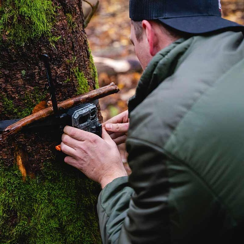 Person setting up trail camera